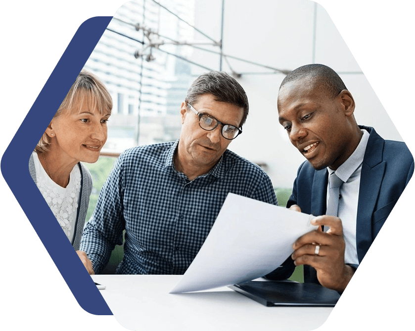 Three people are looking at a paper.